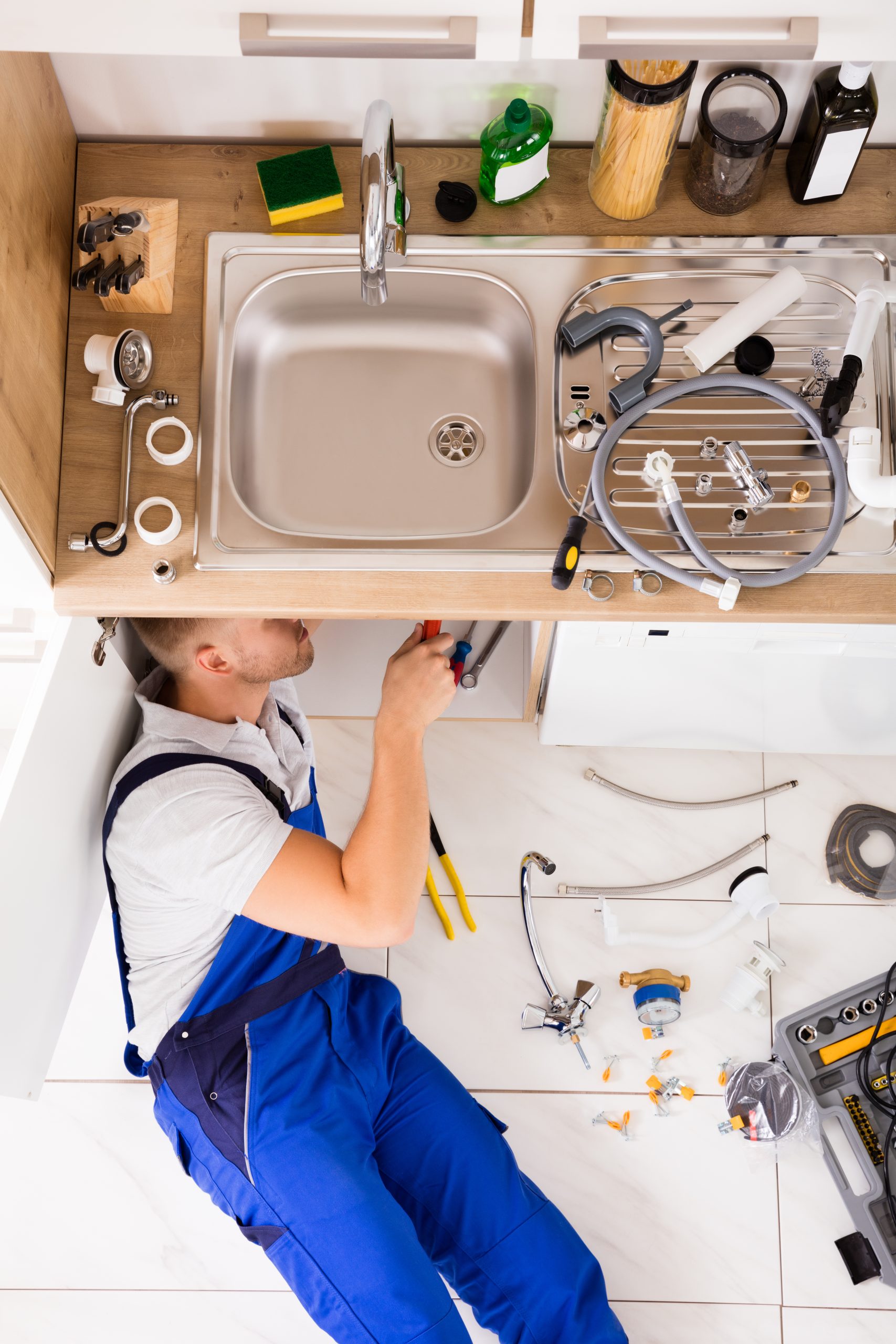 High angle view of plumber fixing sink High angle view of plumber fixing sink