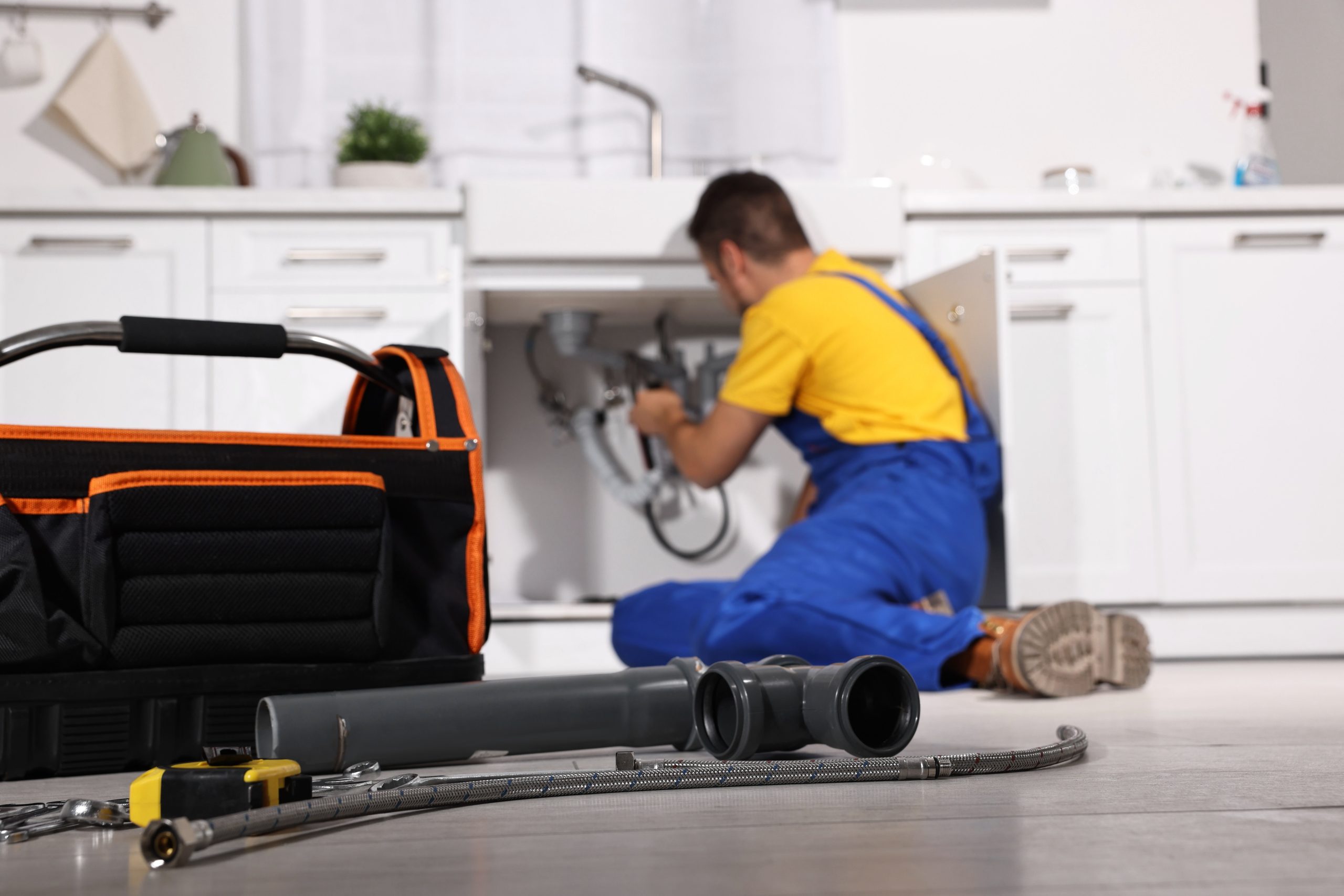 Plumber working under a sink
